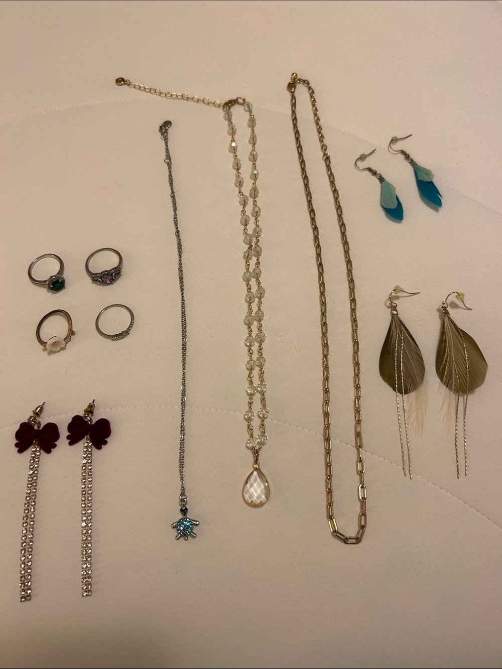 Random jewelry, costume jewelry, rings, feather earrings, gold chain, etc.